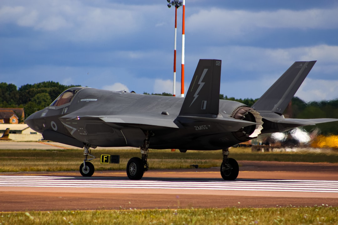 a fighter jet sitting on top of an airport runway