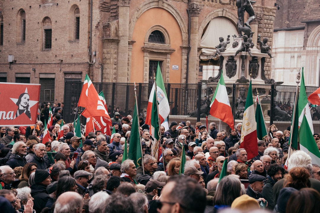 A large group of people holding flags in front of a building