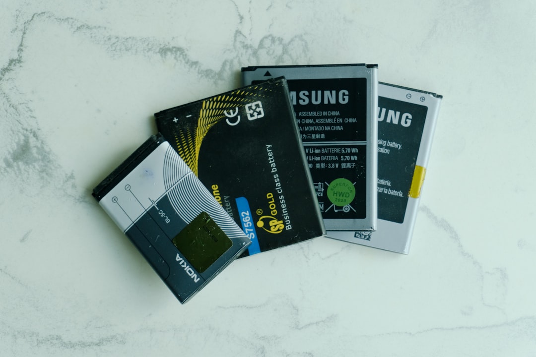 Several old mobile phone batteries on a white surface