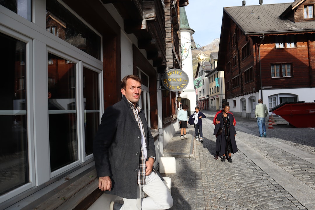a man walking down a street next to tall buildings