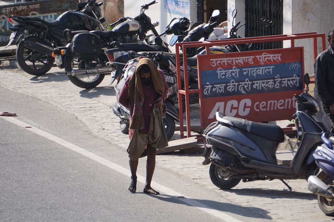 a man walking down a street next to parked motorcycles