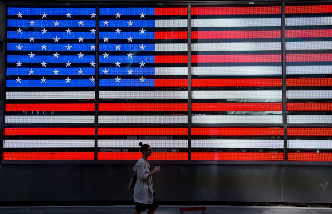 A person walks past a large american flag display.