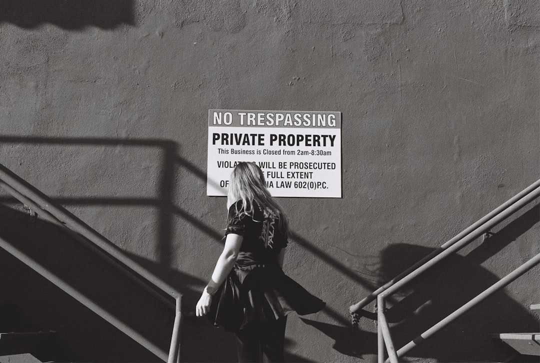 Woman walks up stairs past no trespassing sign