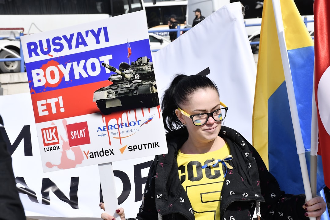 a woman holding a sign with a tank on it