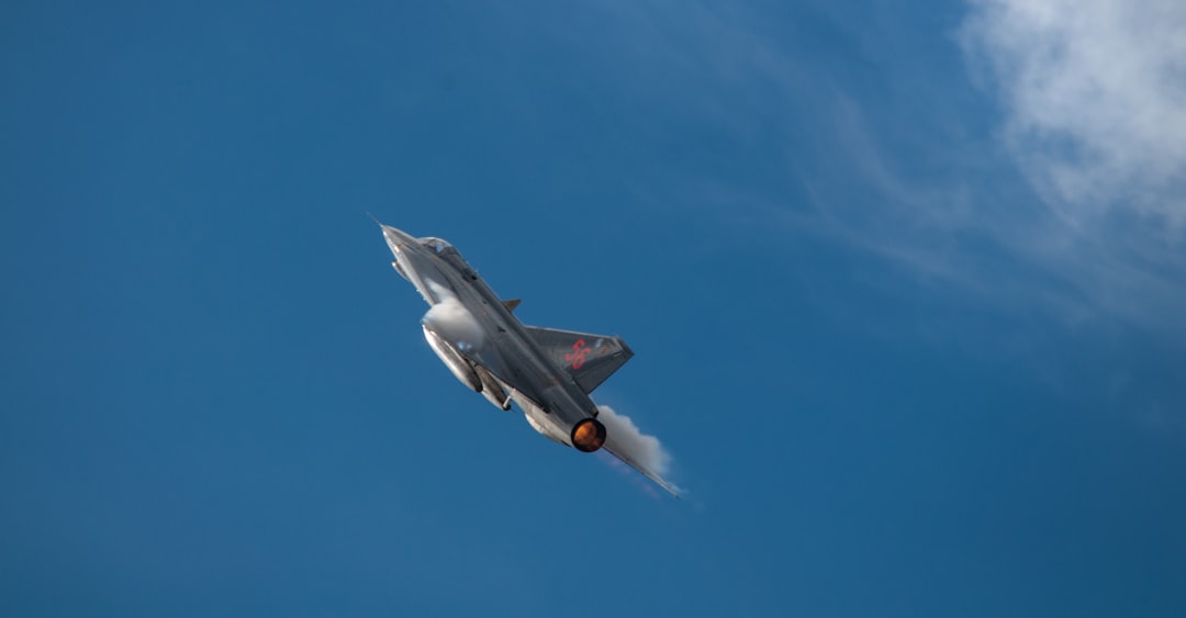 a fighter jet flying through a blue sky