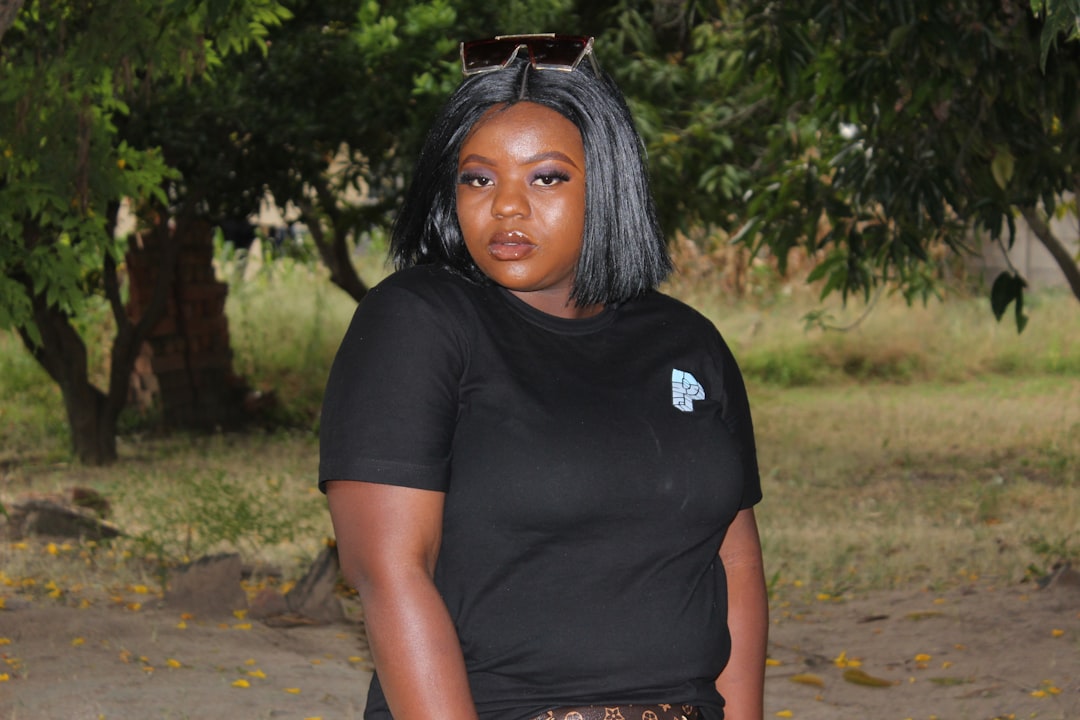 woman in black crew neck t-shirt standing on dirt road during daytime