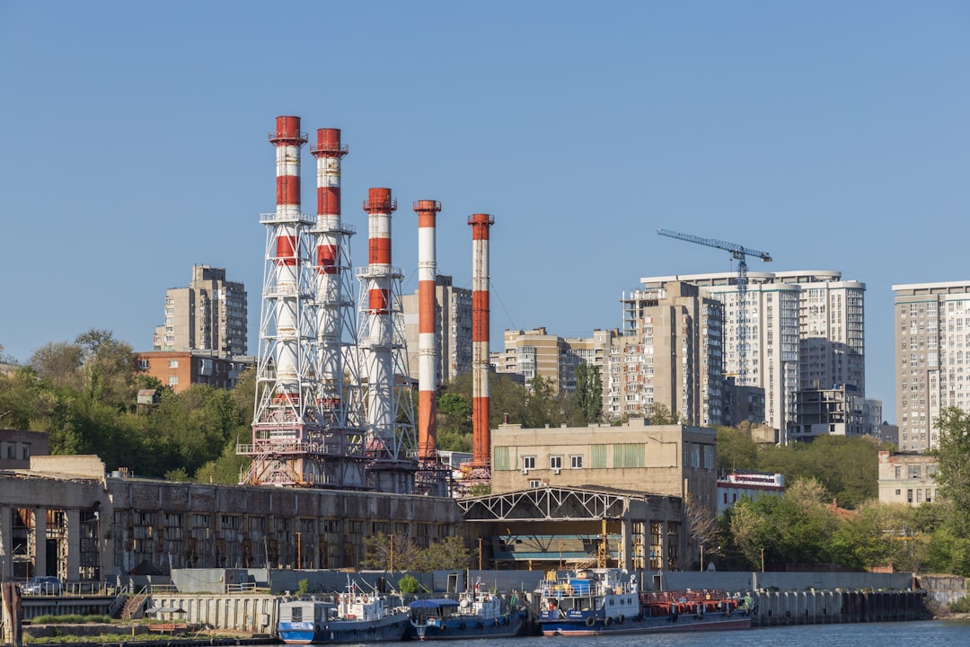 Power plant stands tall with buildings in the backdrop.