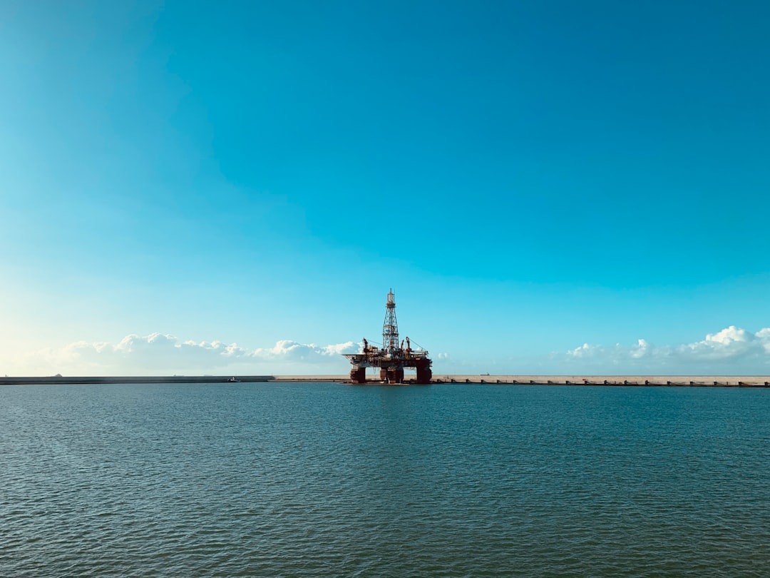 red and white ship on sea under blue sky during daytime
