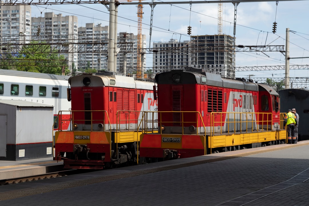 Two red and yellow locomotives parked at the station.
