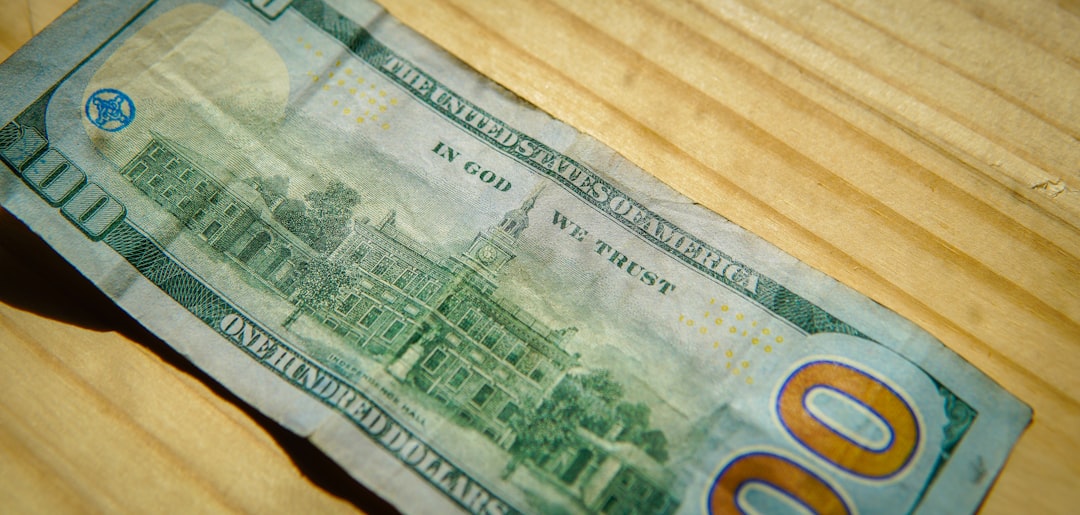 A hundred dollar bill on a wooden surface