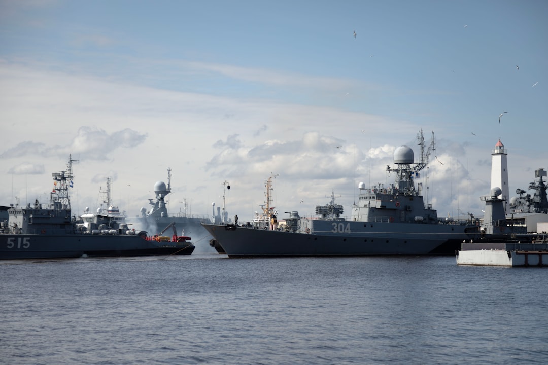 Naval ships are docked at a port.