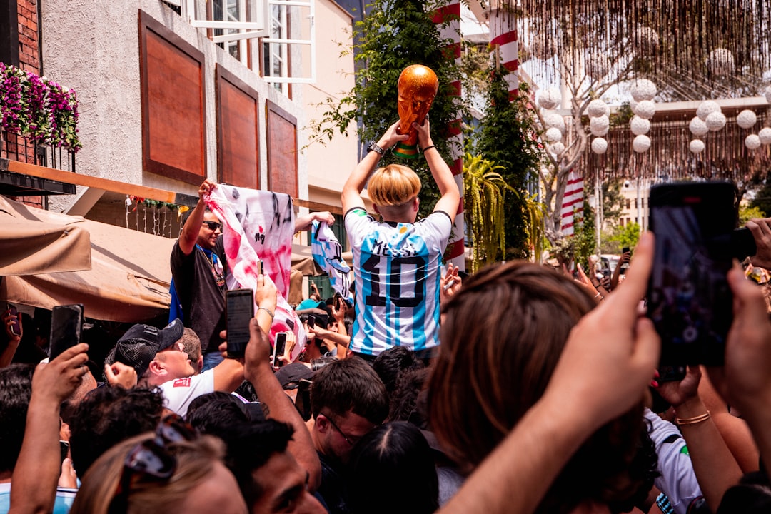 a crowd of people standing around a man holding a basketball