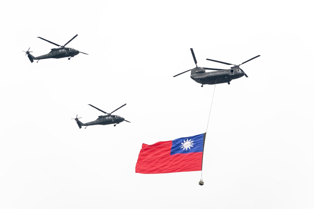 A group of military helicopters flying over a flag