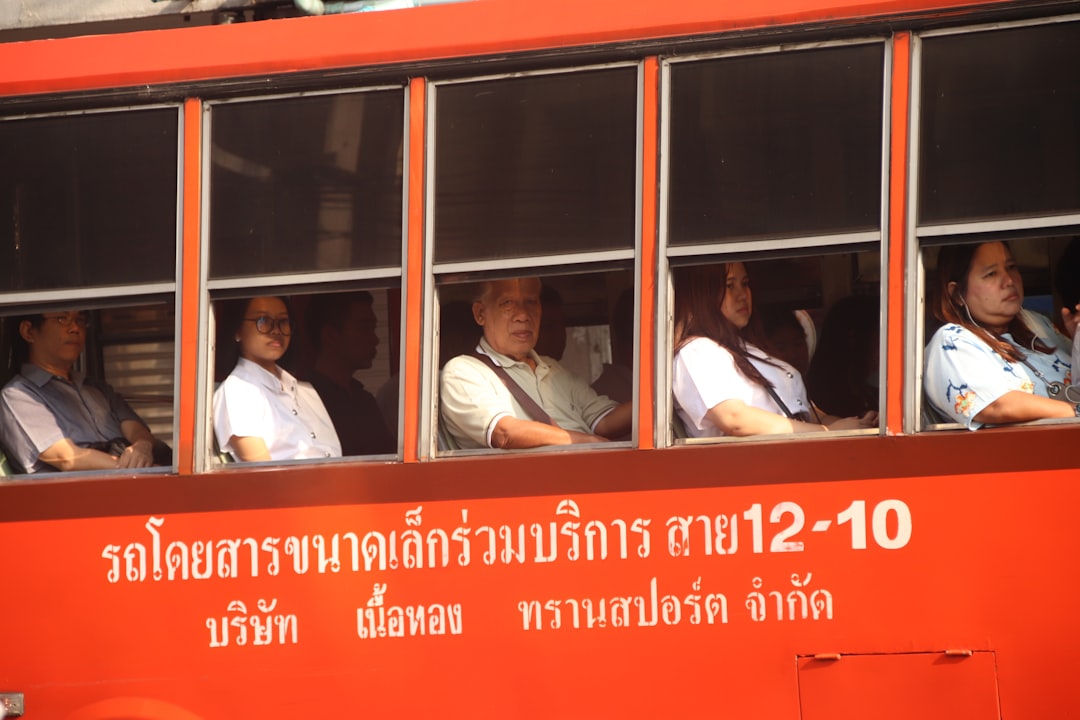 man in white dress shirt sitting on red and white train