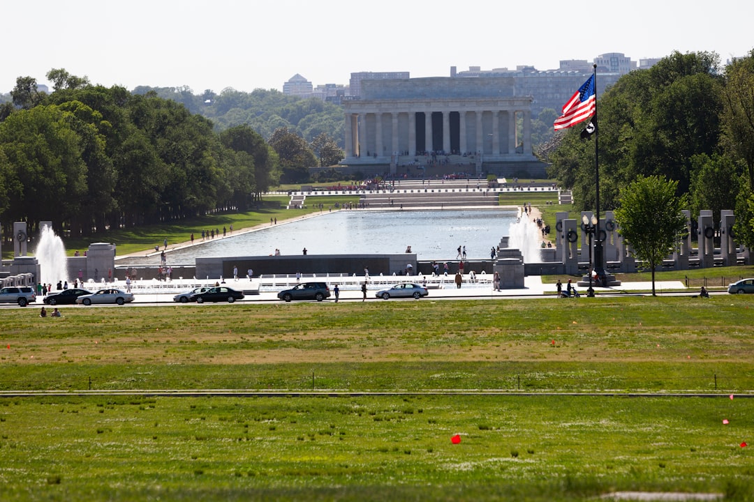Lincoln memorial and reflecting pool with american flag flying.