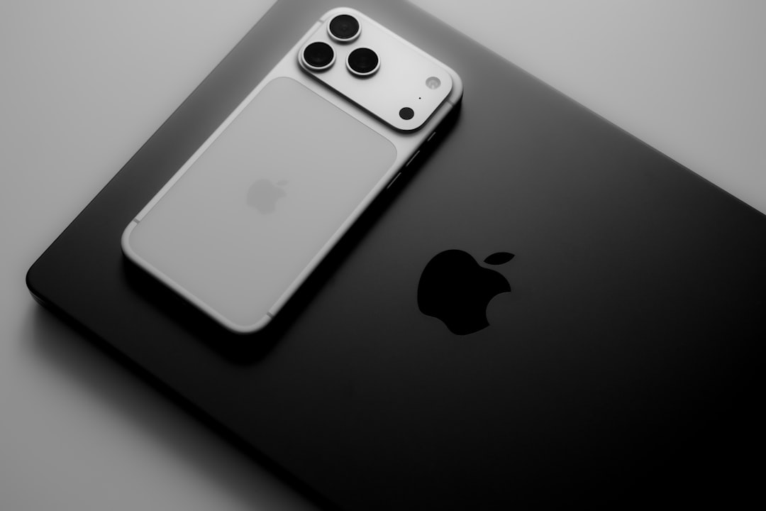 Silver smartphone resting on a black laptop