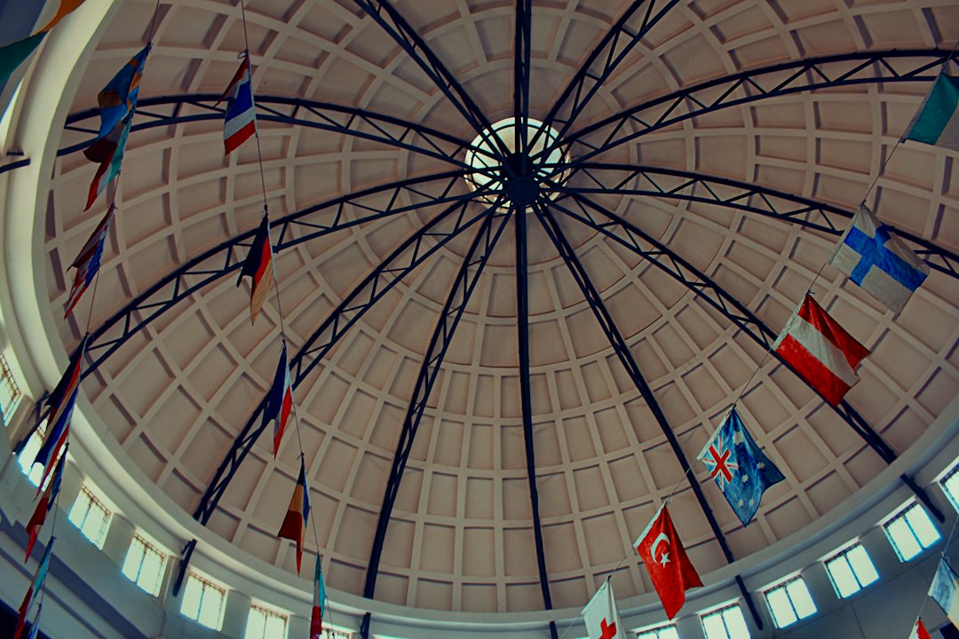 Flags of various nations hang inside a domed building