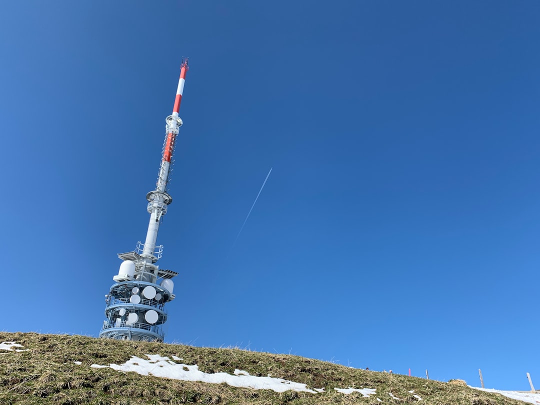 white and red tower near grass field