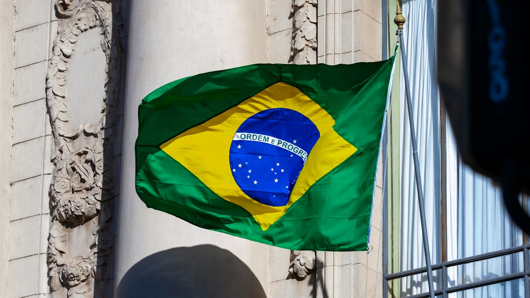 A brazilian flag waves proudly against a building