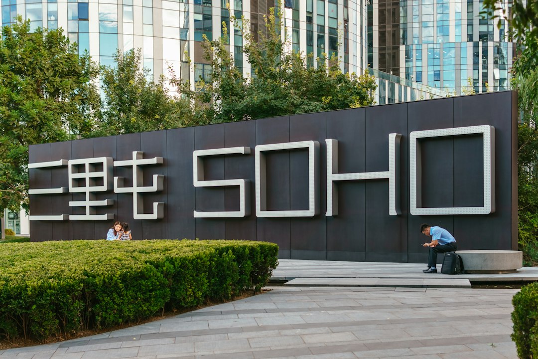 A man sitting on a bench in front of a sign