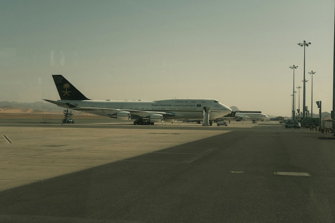 A large airplane parked on an airport tarmac under sunlight