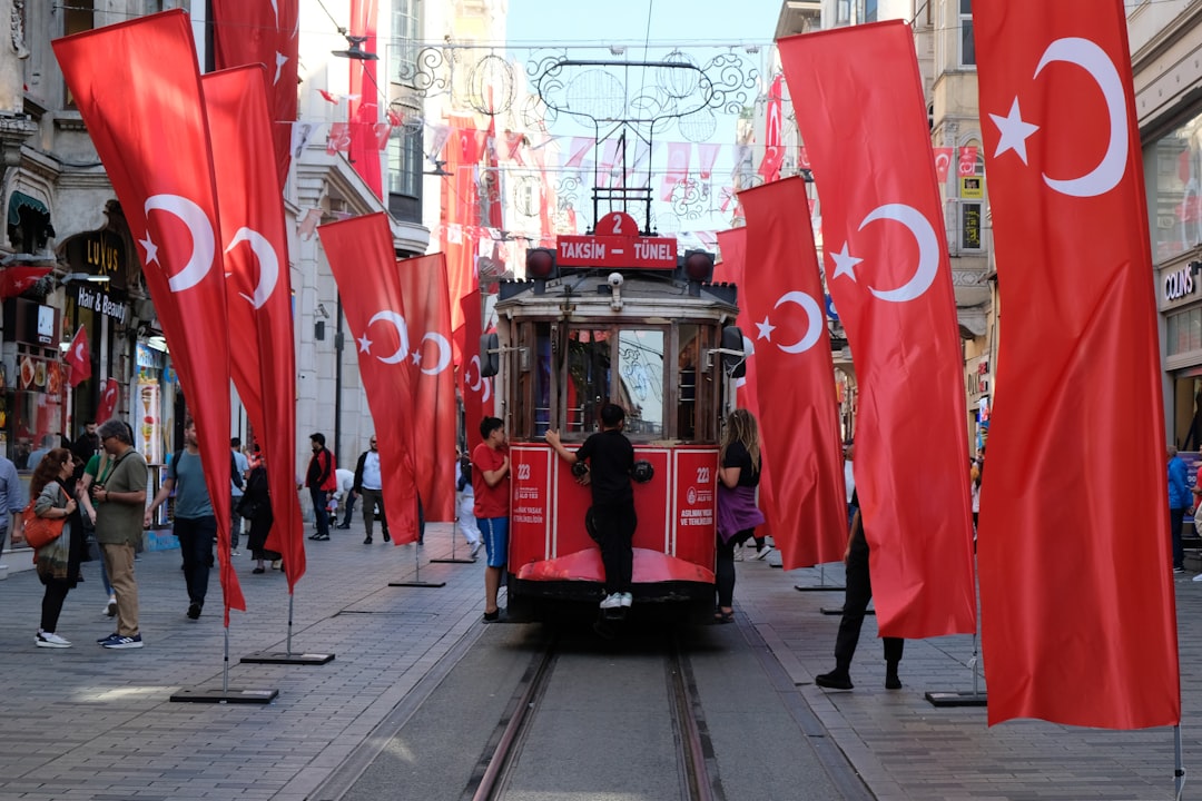 a trolley car on a street with flags on it