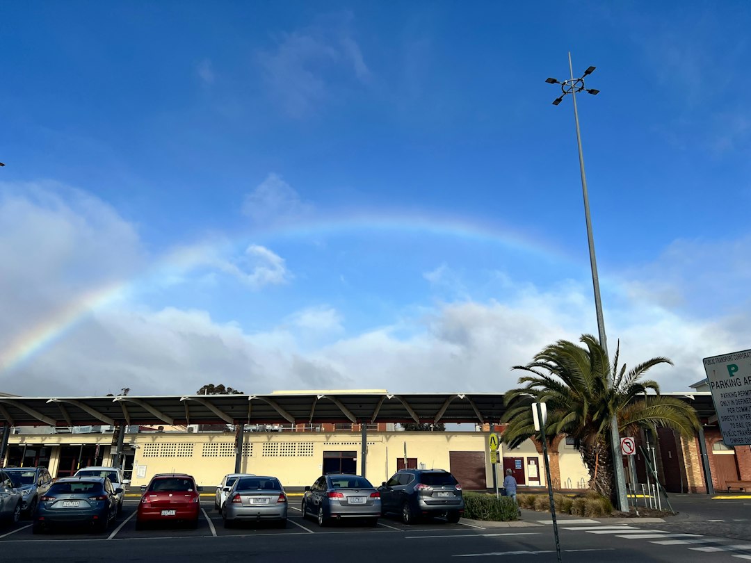 A parking lot with a rainbow in the sky