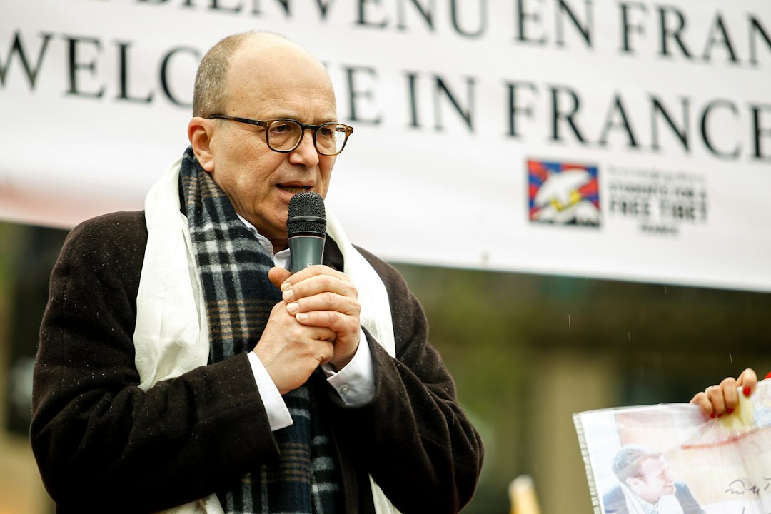 a man speaking into a microphone in front of a sign
