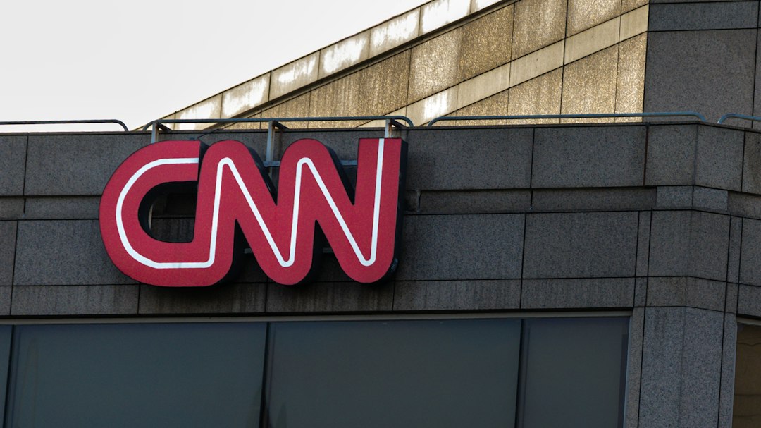 The red CNN logo mounted on a grey stone building facade