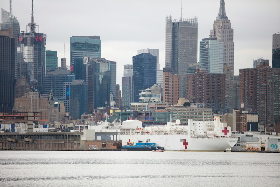 white ship on body of water near city buildings during daytime