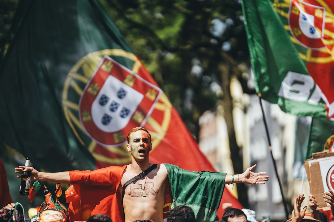 Enthusiastic man with portuguese flag cape and outstretched arms