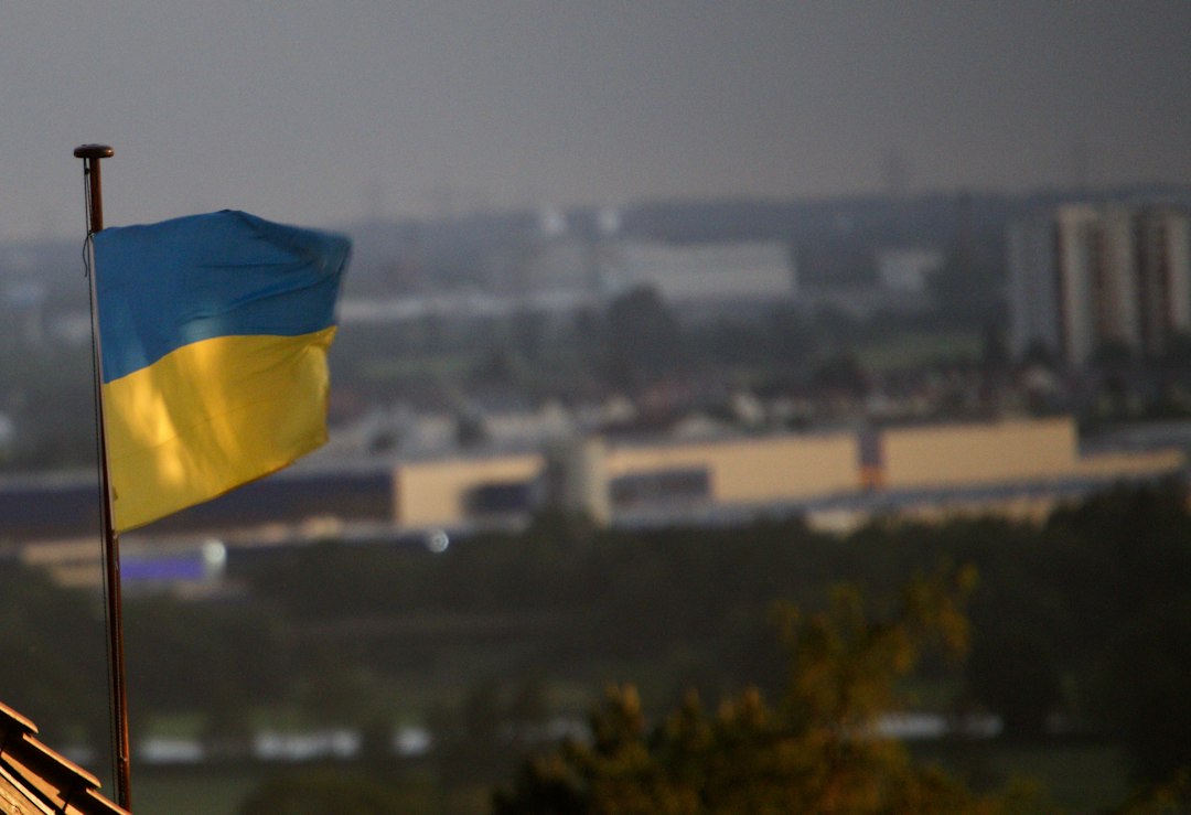 a flag on top of a building with a city in the background